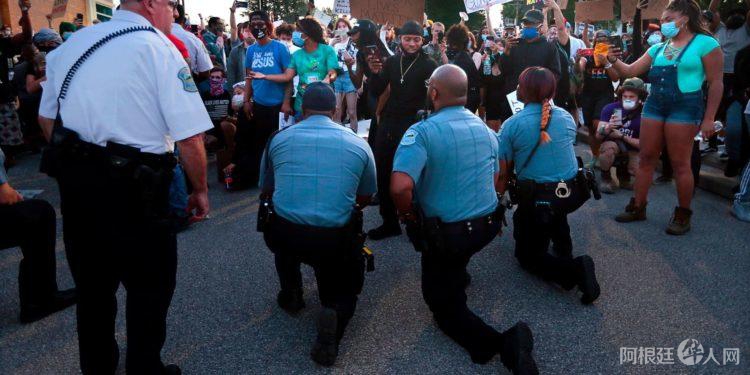 美警察为何用单膝跪地与和平抗议者站在一起？