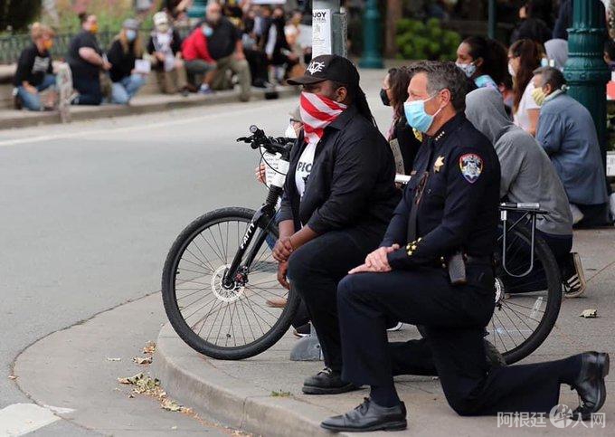 美警察为何用单膝跪地与和平抗议者站在一起?