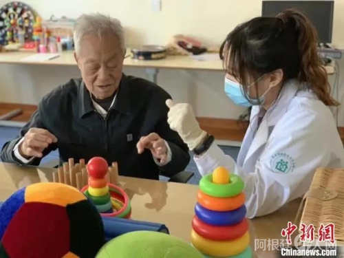资料图：北京一家社区养老服务中心内，工作人员与老人一起做游戏。　杜燕 摄
