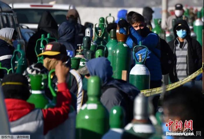 当地时间7月23日,秘鲁第二大城市阿雷基帕,新冠肺炎患者的家属排队给医用氧气瓶充电。 点击进入下一页