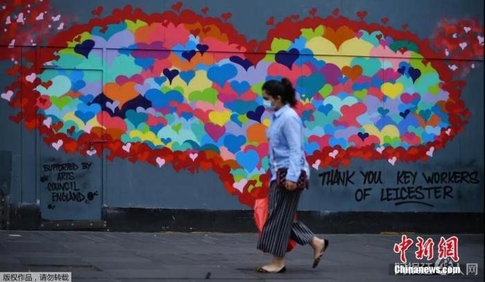 当地时间6月29日,英国莱斯特市中心,行人走过一幅为感谢疫情中做出贡献的工作人员而作的壁画。 点击进入下一页