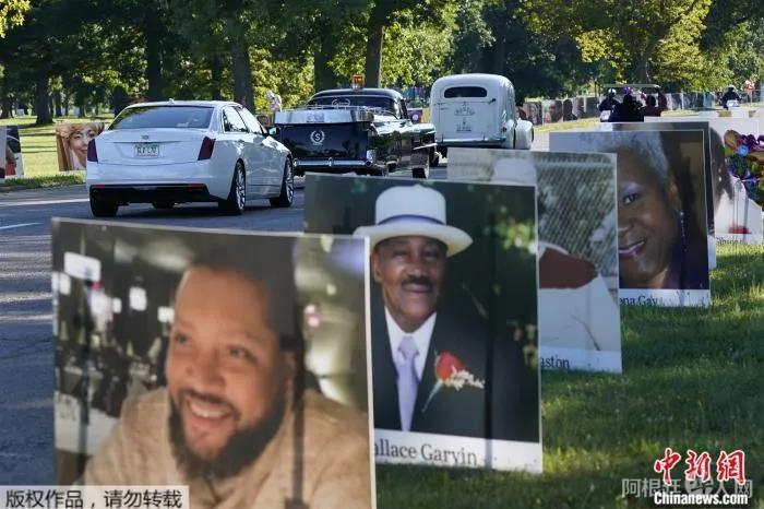 当地时间8月31日,在美国底特律的贝尔岛公园,一队车辆驶过新冠逝者的照片。 点击进入下一页