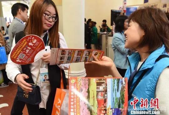 图为诸多日本企业在发放宣传资料，推介所推出的各项便利措施，吸引更多中国游客。