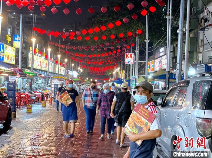 12月12日晚，吉隆坡亚罗街上客流稀疏，各店揽客员工颇显寂寥。中新社记者 陈悦 摄