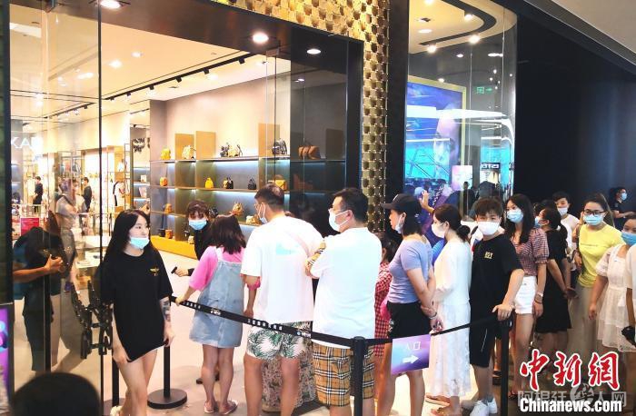 图为8月26日游客在三亚国际免税城内排队进店购物。　尹海明 摄
