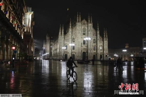 资料图:当地时间10月22日,意大利米兰,男子骑车经过一座哥特式大教堂。 点击进入下一页