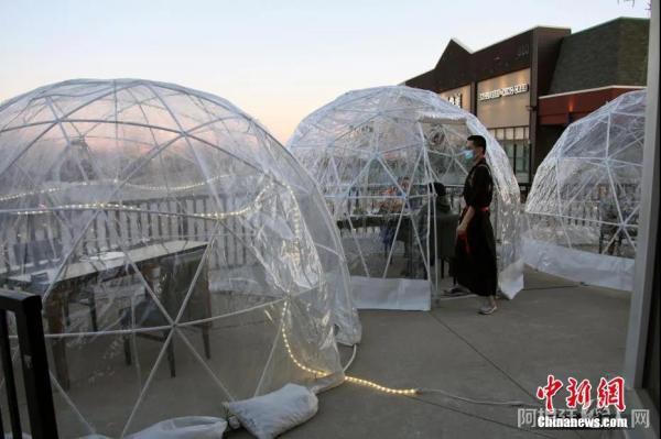 加拿大多伦多一家中餐馆用透明隔离罩搭起室外“气泡餐桌”招徕食客。中新社记者 余瑞冬 摄