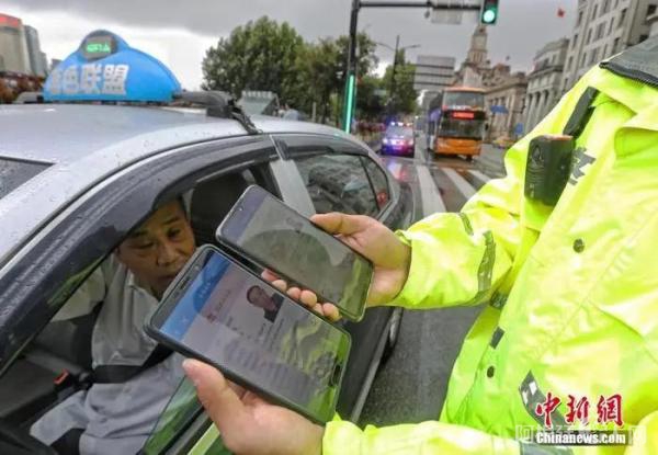 资料图：民警对电子驾驶证进行信息核验。中新社记者 殷立勤 摄
