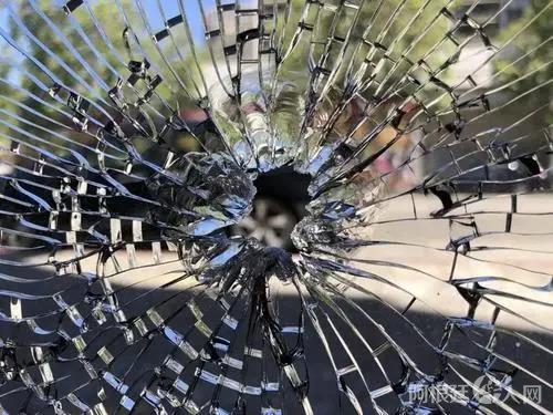 资料图：5月24日，美国奥克兰华埠发生一起枪击案，子弹打中华人理发店的玻璃门窗。(美国《世界日报》/刘先进 摄)