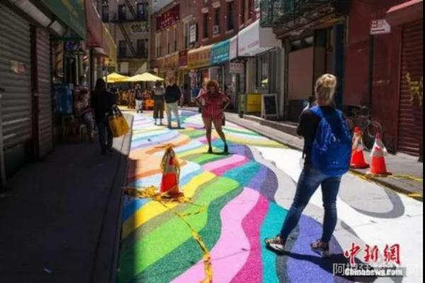 图为美国纽约曼哈顿中国城宰也街的彩绘路面吸引众多游客驻足。 中新社记者 廖攀 摄