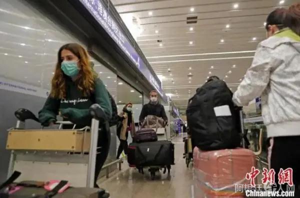 资料图：外籍入境人员推着行李前往上海16个区驻机场分流点。　殷立勤 摄