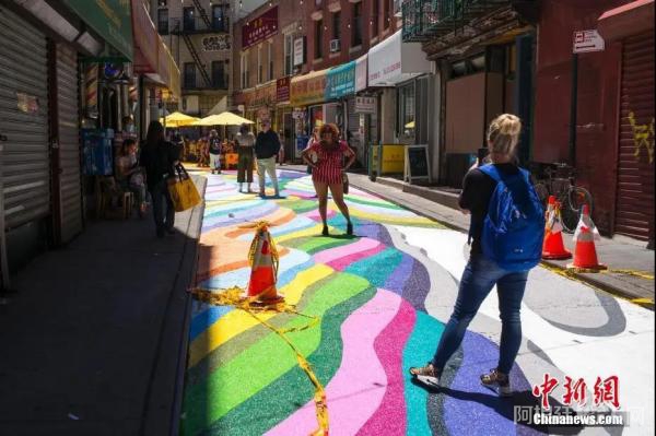 当地时间6月23日，美国纽约曼哈顿中国城宰也街的彩绘路面吸引众多游客驻足。中新社记者 廖攀 摄