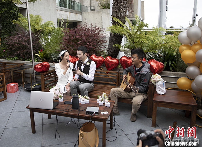 当地时间10月23日，刘知秋(左二)和Stream Wu(左一)在好友的吉他伴奏声中，坐在用红色心形气球点缀的长椅上合唱《往后余生》。当天，他们邀请了8位华人朋友，相聚于旧金山一家中餐厅的户外餐桌，庆祝喜结连理。在这对新婚夫妻看来，2021是他们“在迷雾中寻找确定性的一年”。 中新社记者 刘关关 摄