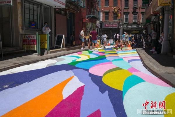 图为美国纽约曼哈顿中国城宰也街的彩绘路面吸引众多游客驻足。中新社记者 廖攀 摄