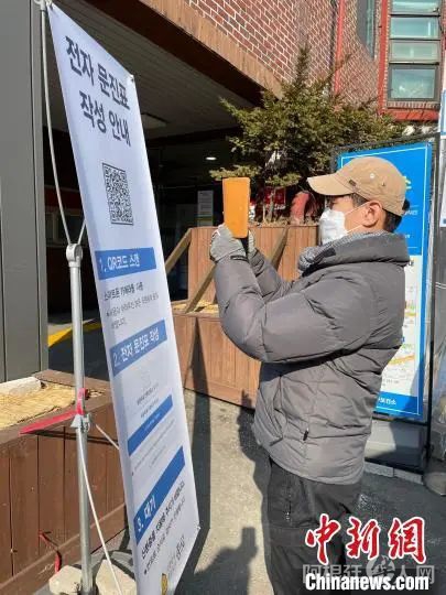 资料图:图为民众在首尔钟路区保健所外扫码准备进行快速抗原检测。 刘旭 摄 资料图:图为民众在首尔钟路区保健所外扫码准备进行快速抗原检测。 刘旭 摄
