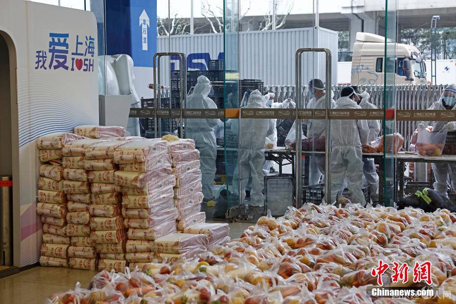 保障人员正在虹口足球场抓紧时间将生活物资分袋。 殷立勤 摄 保障人员正在虹口足球场抓紧时间将生活物资分袋。 殷立勤 摄