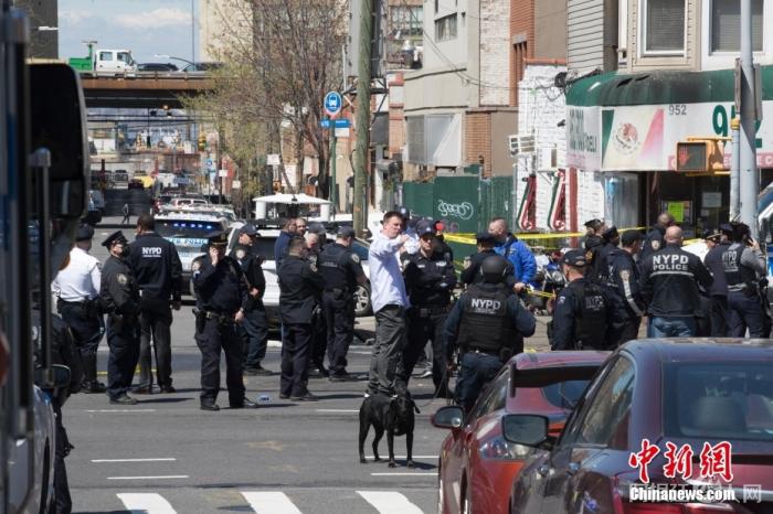 当地时间4月12日，美国纽约市布鲁克林区36街地铁站发生枪击案，至少16人受伤，其中10人直接中枪，大批警力和相关部门人员赶赴现场。图为地铁站外的特勤人员。 中新社记者 廖攀 摄