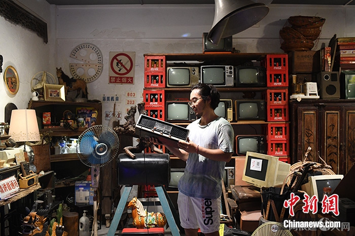 图为4月24日，武楷斯在“永续旧物”店展示老式收音机。 中新社记者 陈楚红 摄