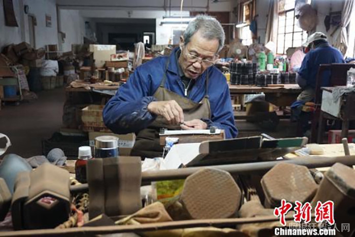 资料图为无锡梅村一家二胡工坊中，老手艺人正在打磨制作二胡的零部件。　孙权 摄