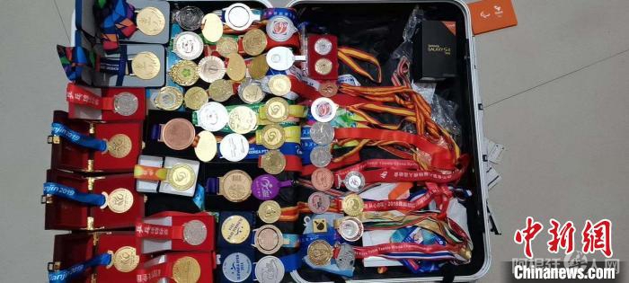 王睿家中装满奖牌的行李箱。王睿妈妈周乐芬供图