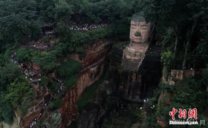 资料图：四川乐山，游客排队下栈道“抱佛脚”。中新社记者 刘忠俊 摄