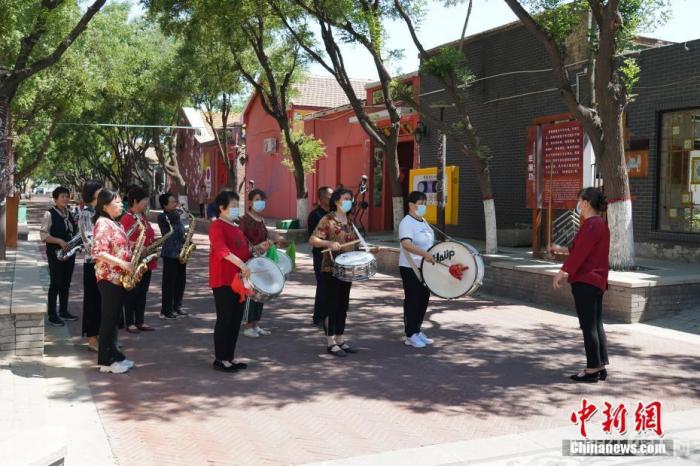 图为5月26日，周窝村村民组建的西洋乐队在街头演奏。 中新社发 徐鹏璐 摄