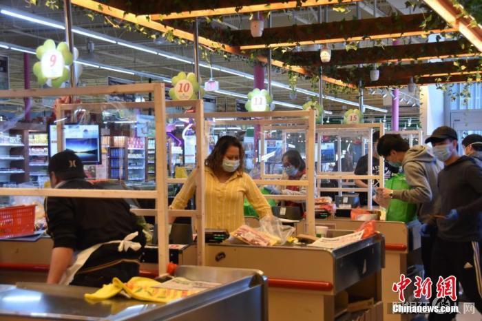 资料图：美国一超市在结账区收银员和顾客之间设置玻璃隔断，防止互相传染。中新社记者 沙晗汀 摄