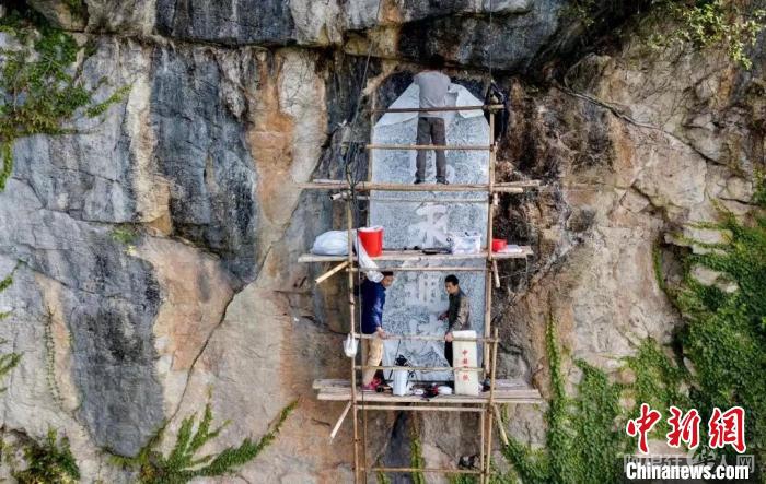 2019年，梁良和团队在大藤峡摩崖上工作。　受访者提供