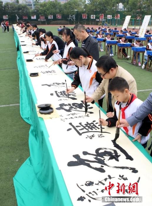 资料图：2017年11月3日，在四川省广安市广安区中石油希望小学操场，师生等在80米长卷上书写“廉”字。 中新社发 廖小兵 摄