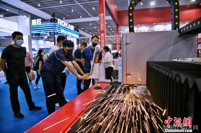 资料图：2022年8月11日，第18届中国(天津)国际装备制造业博览会开幕，激光切割机吸引参观者。 中新社记者 佟郁 摄 