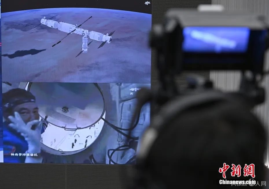 2021年10月16日9时58分，在神舟十三号载人飞船与空间站组合体成功实现自主快速交会对接并按程序完成各项工作后，航天员翟志刚、王亚平、叶光富先后进入天和核心舱。图为北京航天飞行控制中心屏幕显示翟志刚打开天和核心舱舱门。中新社记者 侯宇 摄