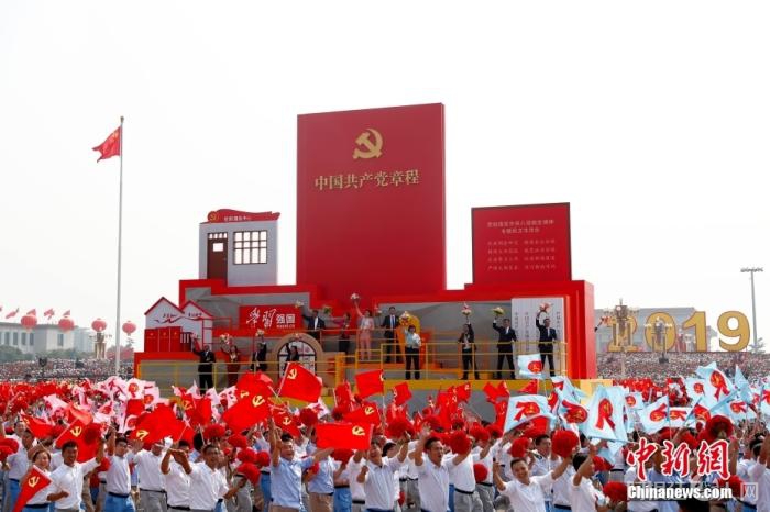 资料图：2019年10月1日，庆祝中华人民共和国成立70周年大会在北京天安门广场隆重举行。群众游行中的“从严治党”方阵走过天安门广场。 中新社记者 富田 摄 　