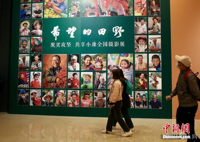 4月9日，由中国文学艺术界联合会、中国国家博物馆和中国摄影家协会联合主办的“希望的田野——脱贫攻坚 共享小康全国摄影展”在国家博物馆南厅正式开幕。本次展览通过不同时期近150名摄影家的近180幅作品，生动记录脱贫攻坚这一伟大历史实践，以影像的力量展示和反映全面建成小康社会取得的伟大成就。展览共分为攻坚与圆梦两个部分，包含产业扶贫、就业扶贫、异地搬迁扶贫、教育扶贫、文化扶贫等内容。图为观众进入展厅参观展览。
中新社记者 易海菲 摄