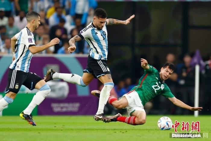 当地时间11月26日，2022卡塔尔世界杯小组赛C组第二轮阿根廷(蓝)与墨西哥的比赛在卢赛尔体育场举行。最终阿根廷队2：0战胜墨西哥队。图为阿根廷球员奥塔门迪(中)与墨西哥球员伊尔文·洛萨诺(右)拼抢。 中新社记者 富田 摄 