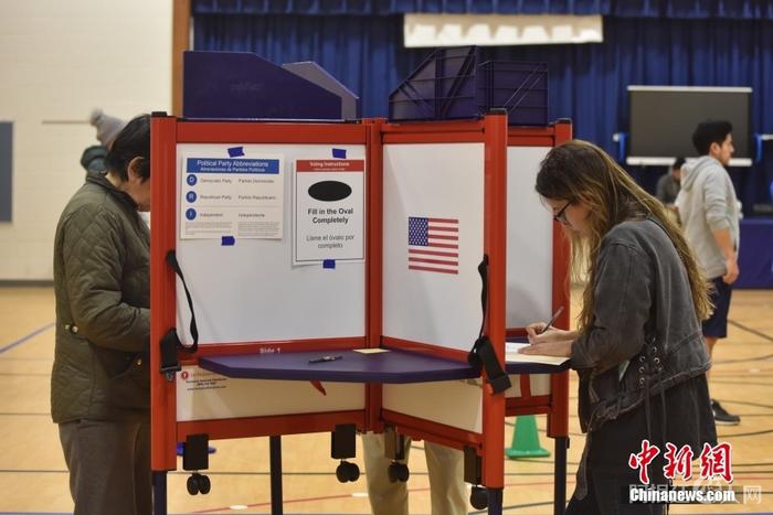 当地时间11月8日，美国中期选举举行，全美50个州以及华盛顿特区陆续开启投票站。图为位于弗吉尼亚州阿灵顿的一处投票站，民众正在填写选票。 中新社记者 沙晗汀 摄