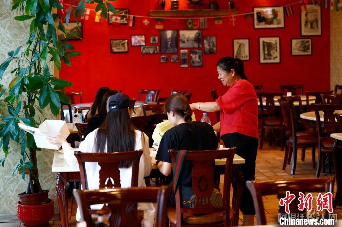 在“老上海”中餐馆，老板苏丽萍为华人球迷服务 中新社记者 富田 摄