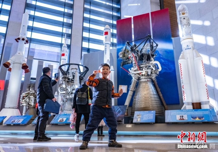 2月24日，“逐梦寰宇问苍穹——中国载人航天工程30年成就展”在位于北京的中国国家博物馆开幕。该展览为期3个月，展示包括可入内参观的中国空间站天和核心舱1:1模型、空间站组合体1:4模型等，并首次展出新一代运载火箭、载人飞船及月面着陆器等未来载人登月主要飞行产品模型，是首次全面系统面向公众展示工程发展历程和建设成就。图为一名小朋友在中国各型运载火箭及火箭发动机模型展品前拍照。中新社记者 侯宇 摄