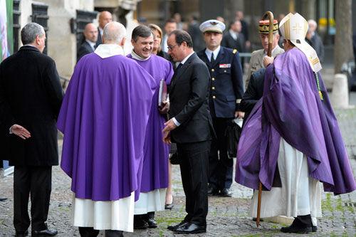 27日，法国总统奥朗德在出席道达尔前总裁马哲睿葬礼时，与主持葬礼的神职人员交谈。法国总理瓦尔斯和多位政府部长也出席了葬礼。