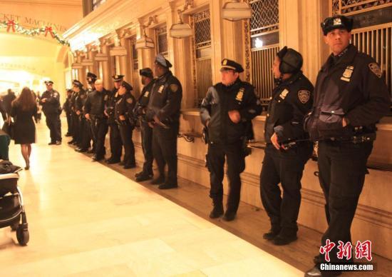 12月8日晚，纽约黑人小贩埃里克·加纳扼喉致死案引发的抗议浪潮已经持续六个夜晚。图为中央火车站内正执勤的警察。 中新社发 阮煜琳 摄