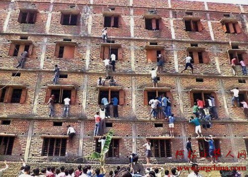 在印度一场考试中，诸多家长铤而走险扮演“蜘蛛侠”，攀爬考试中心给孩子们传递小抄。