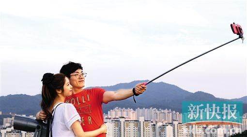 ■用自拍神器自拍已成为世界各地人们的潮流。图为7月10日,两名游客在韩国光州塔用手机自拍。 新华社发