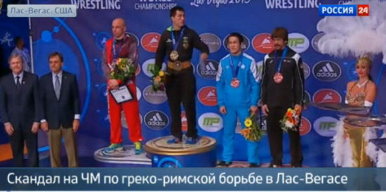 摔跤冠军赛上，俄罗斯选手在发现国歌放错后立刻示意工作人员。（视频截图）